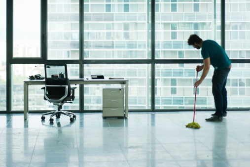 Janitor mopping empty office